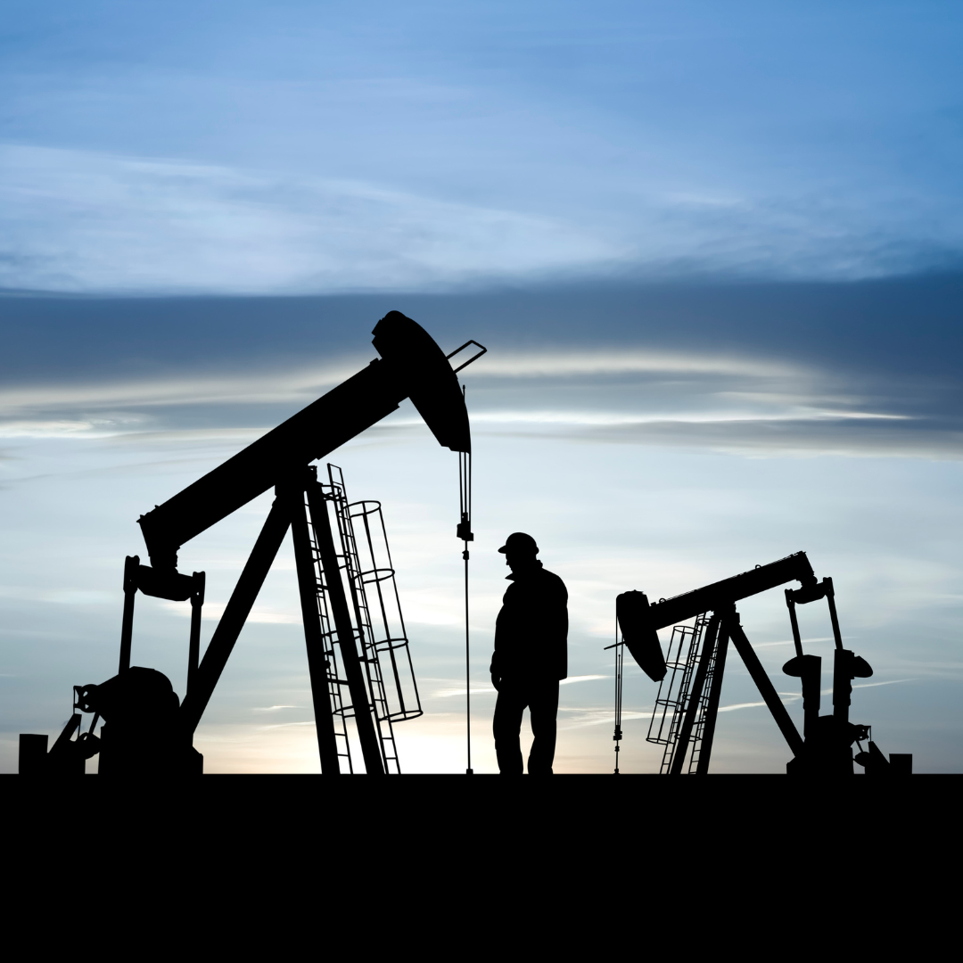 Oil and Gas Mineral producing property drilling with man standing during sunrise or sunset - blue background on oil property